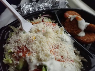 Sebze salatalı kızarmış falafel paket plastik tabakta.