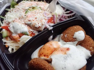 Sebze salatalı kızarmış falafel paket plastik tabakta.