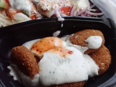 Sebze salatalı kızarmış falafel paket plastik tabakta.