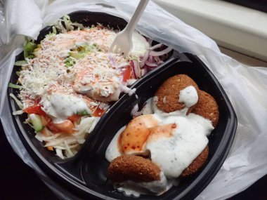 Sebze salatalı kızarmış falafel paket plastik tabakta.