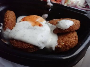Sebze salatalı kızarmış falafel paket plastik tabakta.