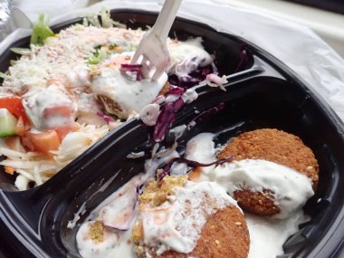 Sebze salatalı kızarmış falafel paket plastik tabakta.