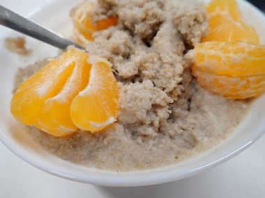 Kahvaltı için beyaz yulaf lapası ve mandalina.