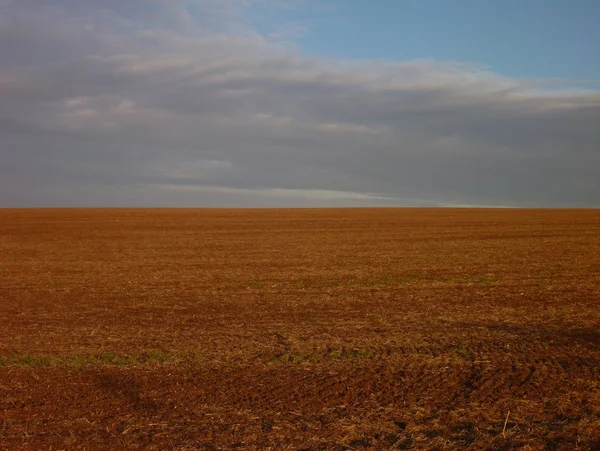 Gepflügtes Feld mit brauner Erde — Stockfoto