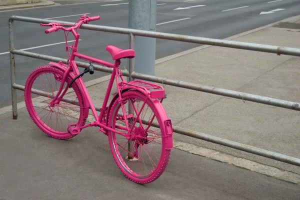 Bicicleta rosa trancada no corrimão — Fotografia de Stock