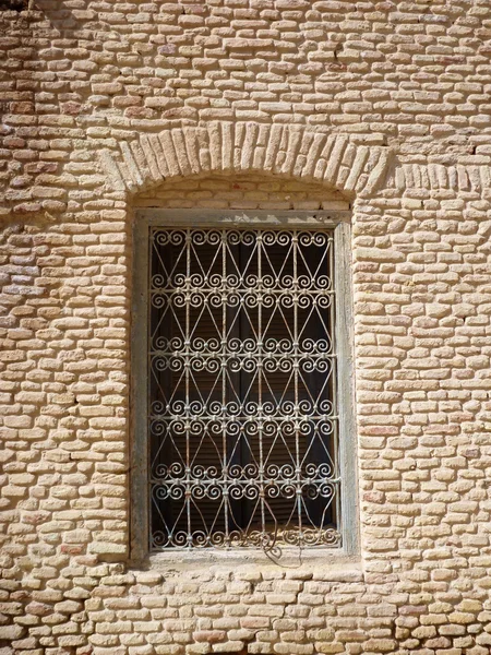 Una ventana con barras decorativas en una pared de ladrillo — Foto de Stock