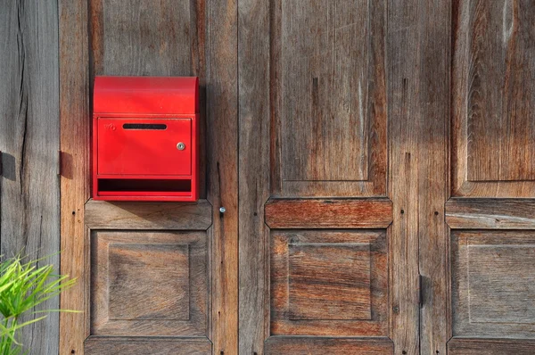 Red mailbox on wood door background — Stock Photo, Image