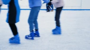 İnsanlar buz pateni pistinde kayıyor. Buz pateni pisti patenli insanlarla dolu..