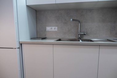 İç mekan. Modern tarzda beyaz mutfak. Mutfakta güzel bir ışık var..