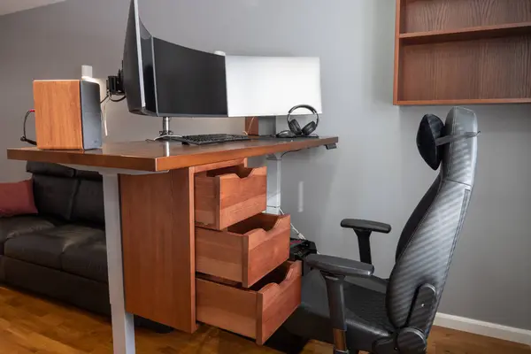 General view of home workplace of pro gamer with professional gaming setup on desktop. Modern powerful PC full RGB light inside, display with shooter game, armchair. Gaming studio of cyber sportsman