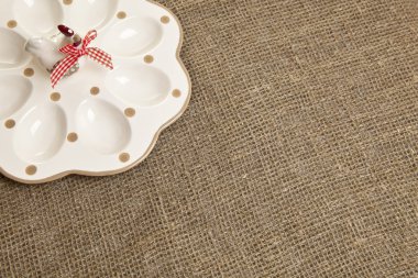 Kahverengi masa örtüsü üzerinde paskalya yumurtaları için boş seramik kap.