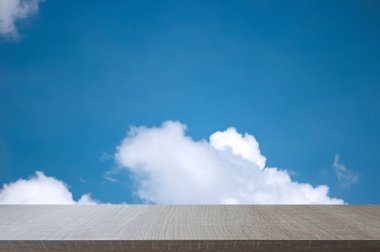 Yumuşak mavi gökyüzü arka plan üzerinde ahşap tablosunun üst kısmındaki.