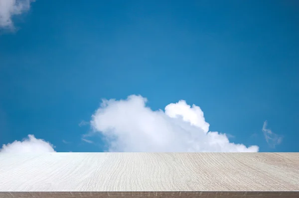 Parte superior de la mesa de madera sobre fondo de cielo azul suave . — Foto de Stock