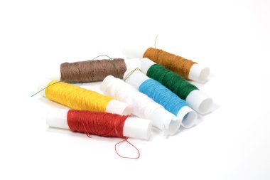 Beyaz arka plan üzerinde birçok renk iplik rulo