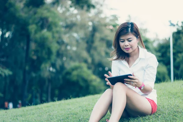 Женщины играют на планшете в парке . — стоковое фото