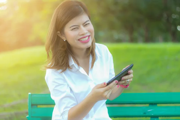 Feliz yong asiático mujeres disfrutando de tableta en parque —  Fotos de Stock