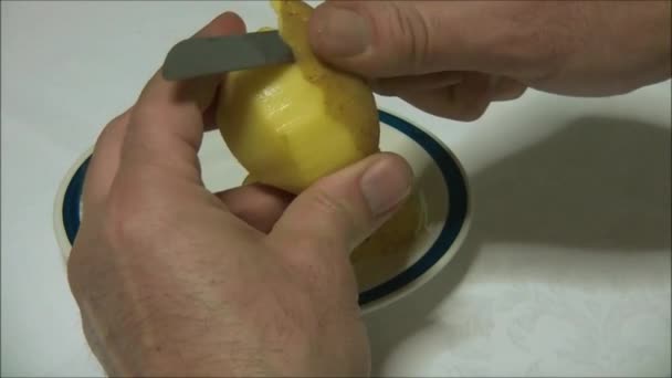 Manos pelando una patata — Vídeo de stock