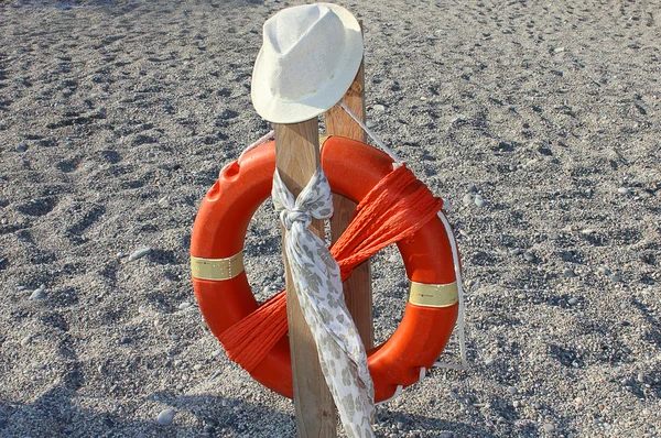 Life buoy with hat and scarf — Stock Photo, Image