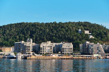 Oslo, Norveç - 6 Eylül 2025: Güneşli bir günde Sorenga 'daki apartman manzarası ve arka planda Ekeberg parkı