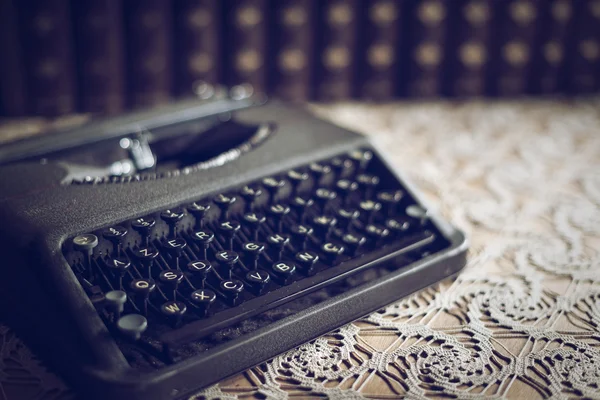 Vintage kirjoituskone taulukossa ja vanhoja kirjoja — kuvapankkivalokuva