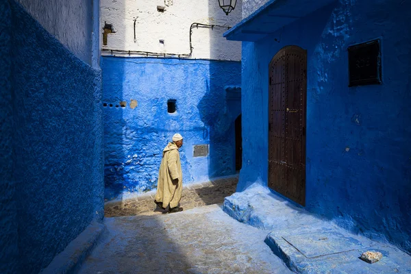 Homem caminhando em uma rua da cidade de Chefchaouen em Marrocos . — Fotografia de Stock