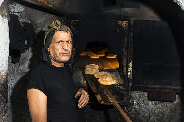Baker στέκεται μπροστά από ένα παραδοσιακό φούρνο, ψήσιμο του ψωμιού στο Fez, Μαρόκο. — Φωτογραφία Αρχείου