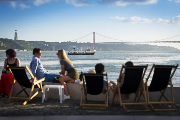 Mensen in een esplanade in Lissabon, Portugal, door de rivier de Taag — Stockfoto