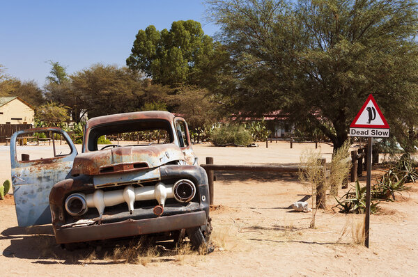 Old rusty car and road sign in Solitaire, Namibia