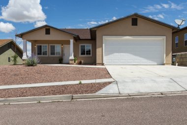 Gallup, New Mexico, ABD 'nin varoşlarında garaj ve garaj yolu olan bir banliyö evinin ön cephesi.