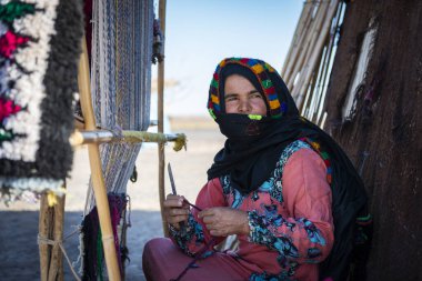 Erg Chebbi, Fas - 12 Nisan 2016: Fas 'taki Erg Chebbi köyünde bir berber kadın geleneksel dokuma tezgahını kullandı.