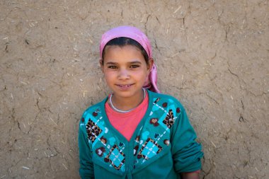 Errachidia, Fas - 12 Nisan 2016: Fas 'ın Errachidia kenti yakınlarındaki bir köyde evinin önünde genç bir kızın portresi.