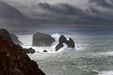 Portekiz, Algarve 'deki bir fırtına sırasında kayaların kayalara çarptığı Carrapateira boyunca sahilin manzarası.