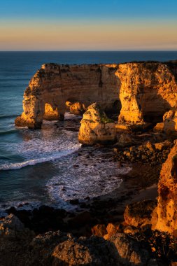 Lagoa yakınlarındaki güzel Marinha Sahili (Praia da Marinha), Algarve, Portekiz, gün doğumunda.