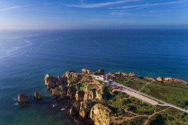 Manzaralı Ponta da Piedade Burnu 'nun, Lagos, Algarve, Portekiz' deki güzel uçurumları ve deniz feneriyle insansız hava aracı fotoğrafı.
