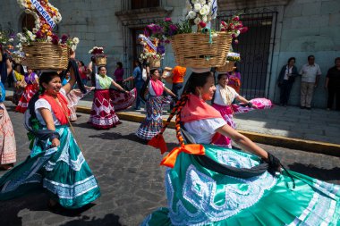 Oaxaca de Juarez, Meksika - 15 Mayıs 2014: Geleneksel renkli elbiseler giyen ve çiçekli sepetler taşıyan bir grup kadın, Meksika 'nın Oaxaca de Juarez şehrinde dans ediyor..