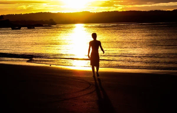 Sahilde bir silüet ile günbatımı