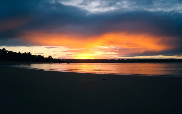 Kumsalda gün batımı bulutlarla
