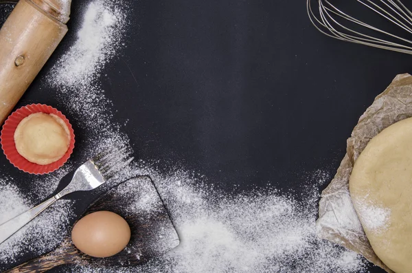 Poudre par farine pâte à tartiner pour produits de boulangerie avec rouleau à pâtisserie en bois sur fond noir . — Photo