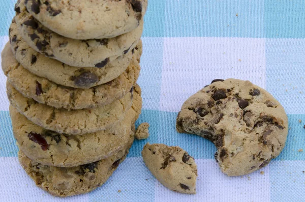 Bolinhos de chocolate em uma mesa de madeira. biscoitos de chocolate chip tiro em uma toalha de mesa azul, close-up . — Fotografia de Stock