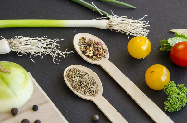 Ingrédients délicieux frais pour une cuisine saine ou la fabrication de salades sur fond noir foncé et planche à découper en bois — Photo