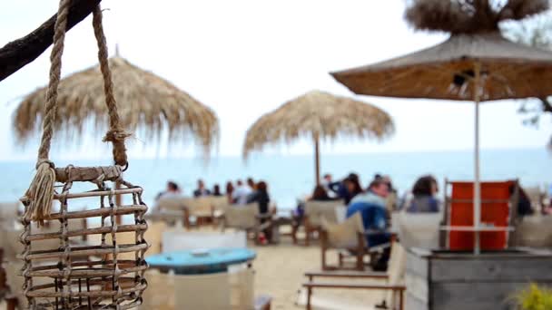 Lâmpada vazia em um bar de praia ou café está balançando em uma brisa do mar em uma costa do mar Negro. Mar desfocado. HD. 1920x1080 — Vídeo de Stock