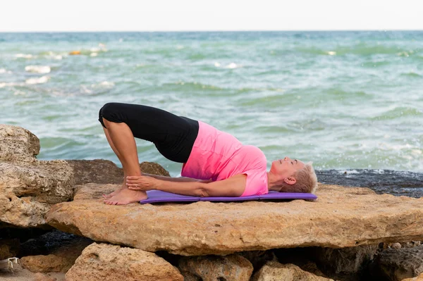 Woman doing yoga exercises at the beach — Stock Photo, Image