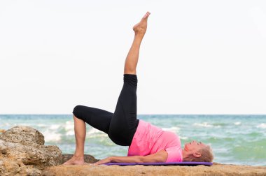 Sahilde gerinen kadın portresi. Kopya alanı olan yoga modeli