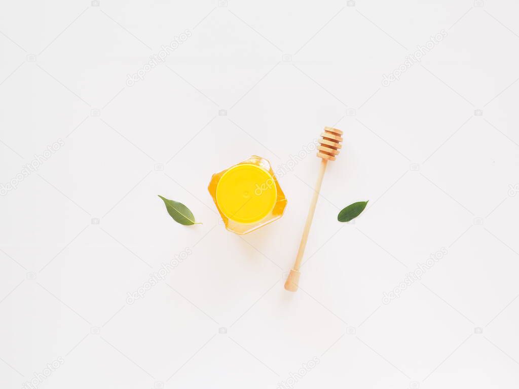 Flat lay jar of honey with dipper and leaves. Bio food concept