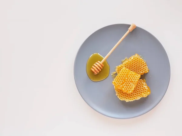 Peine de abeja con cazo en un plato azul. Piso poner natural bio miel — Foto de Stock