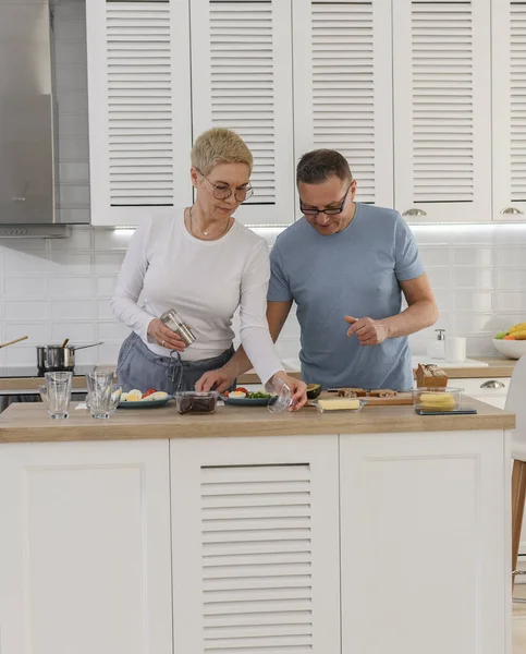 Fröhliches Seniorenpaar kocht gemeinsam gesundes Frühstück in Küche. — Stockfoto