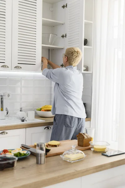 Porträt einer älteren Hausfrau, die in der Küche arbeitet — Stockfoto