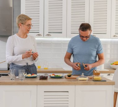 Yaşlı çift, sağlıklı beslenmek için birlikte sebze pişiriyor.