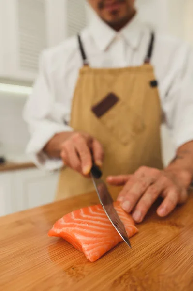 Preparare deliziosi sushi al ristorante. Asiatico maestro affettare pesce salmone — Foto Stock