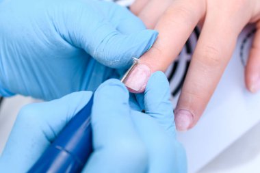 Güzellik salonundaki profesyonel donanımla çivi cilası prosedürünü kapat